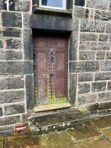 The door to Heptonstall Museum with a large step in front.